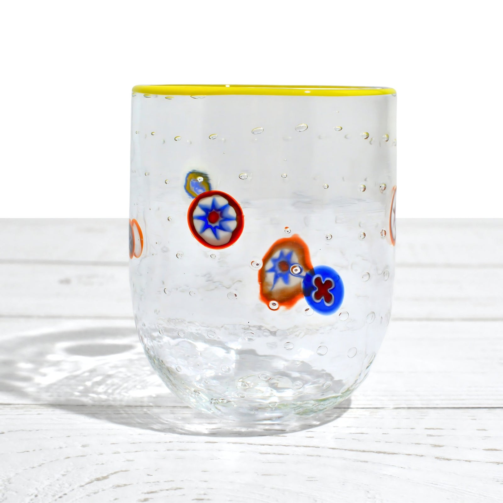 Set of four Gioia Clear Millefiori Murano tumblers with colorful rims, made in Italy, showcasing vibrant hand-blown glass design.