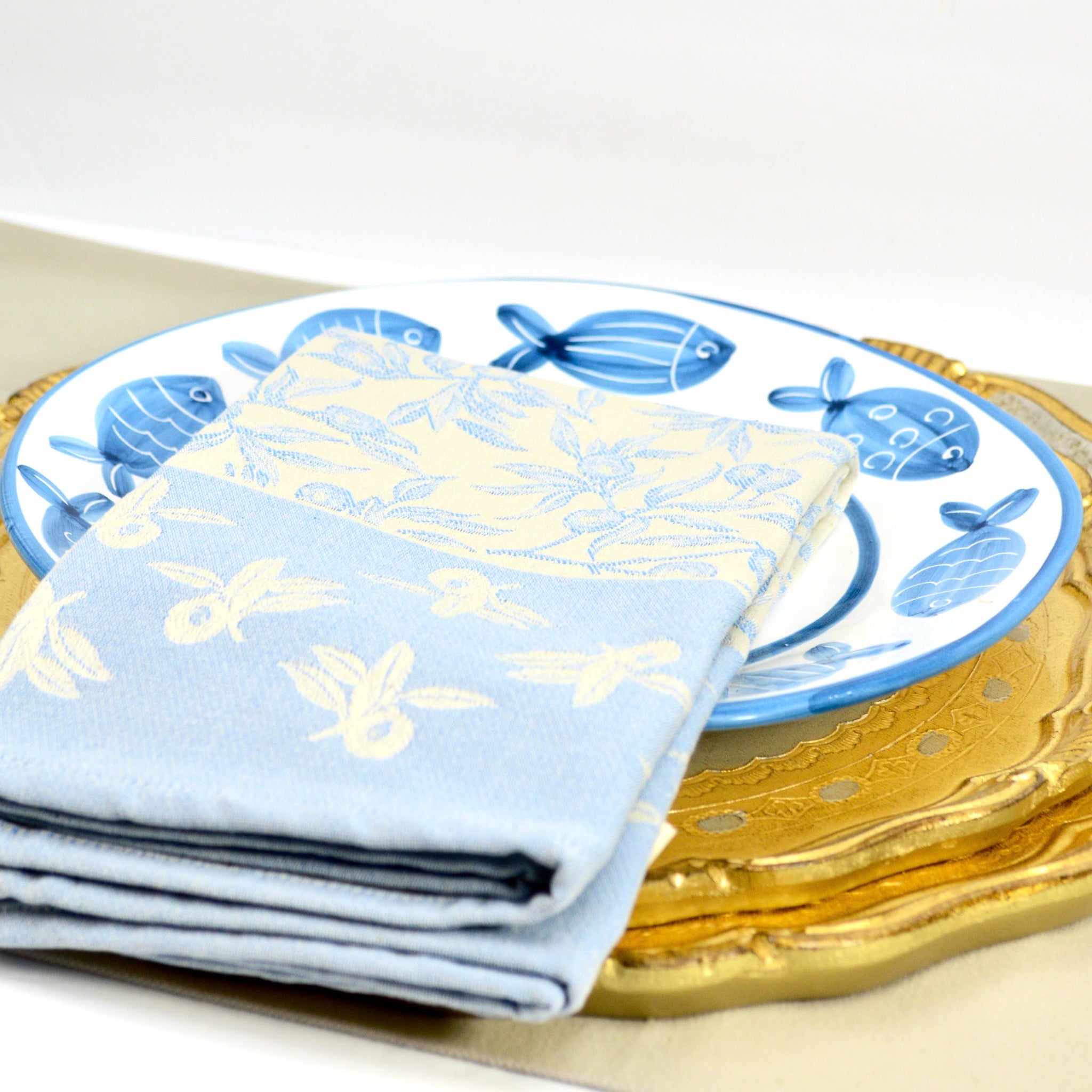 Busatti Oliva kitchen towel with fish and plate design in assorted colors, made in Italy, showcasing vibrant textile details.