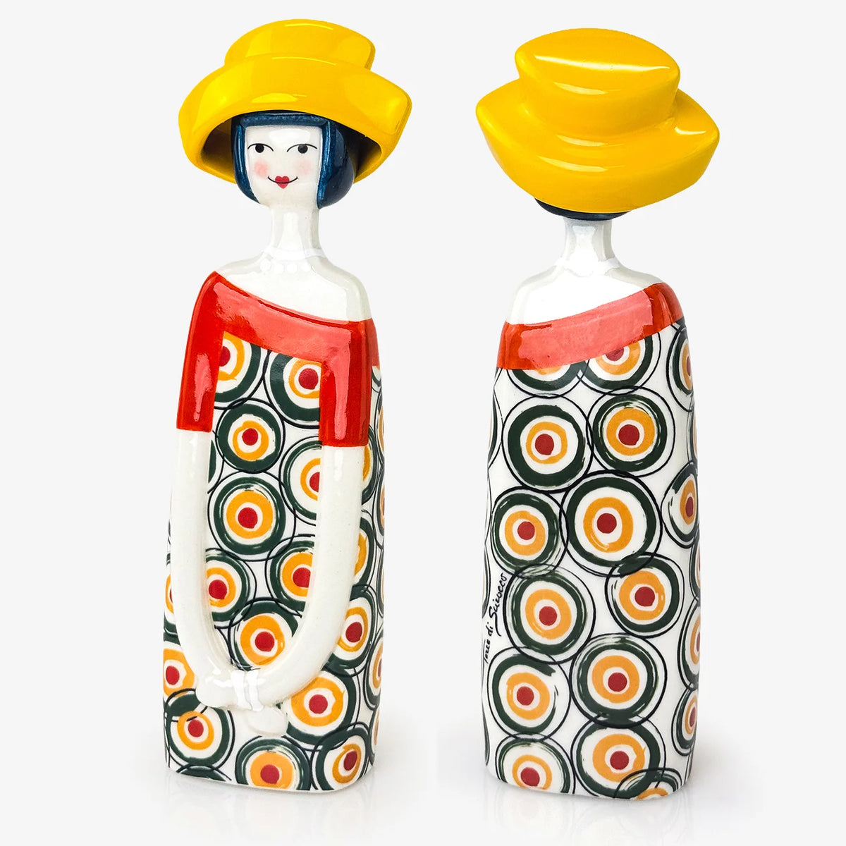 Two decorative ceramic figurines shaped like stylized women, shown side by side against a plain light background. Each figure wears a bright yellow hat and a dress with a repeating circular pattern in black, orange, yellow, and white.