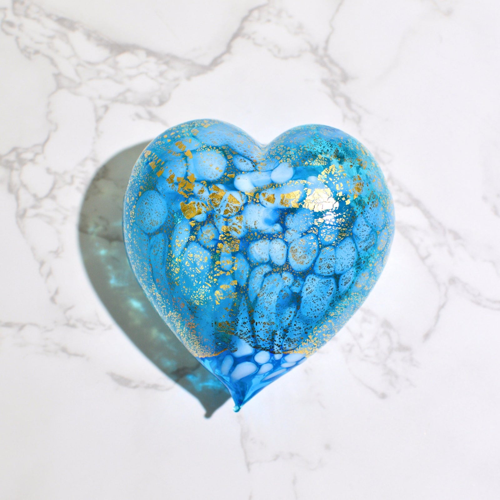 Murano blown glass heart figurine with macchia design, adorned with 24 kt gold patina, surrounded by tulips.