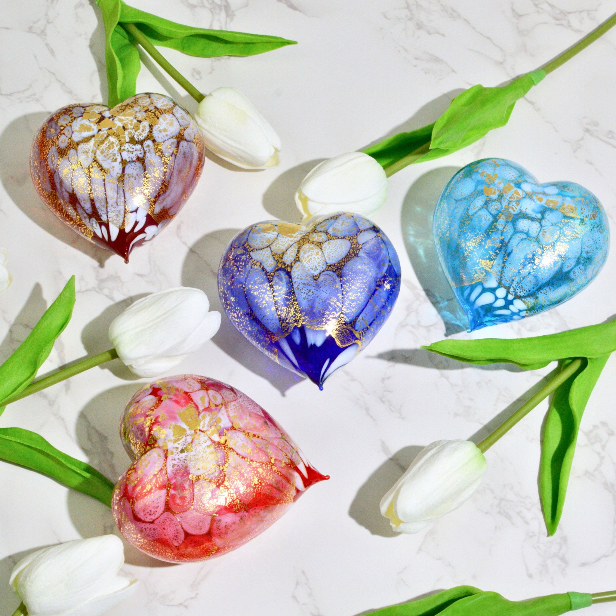 Murano blown glass heart figurine with macchia design, adorned with 24 kt gold patina, surrounded by tulips.