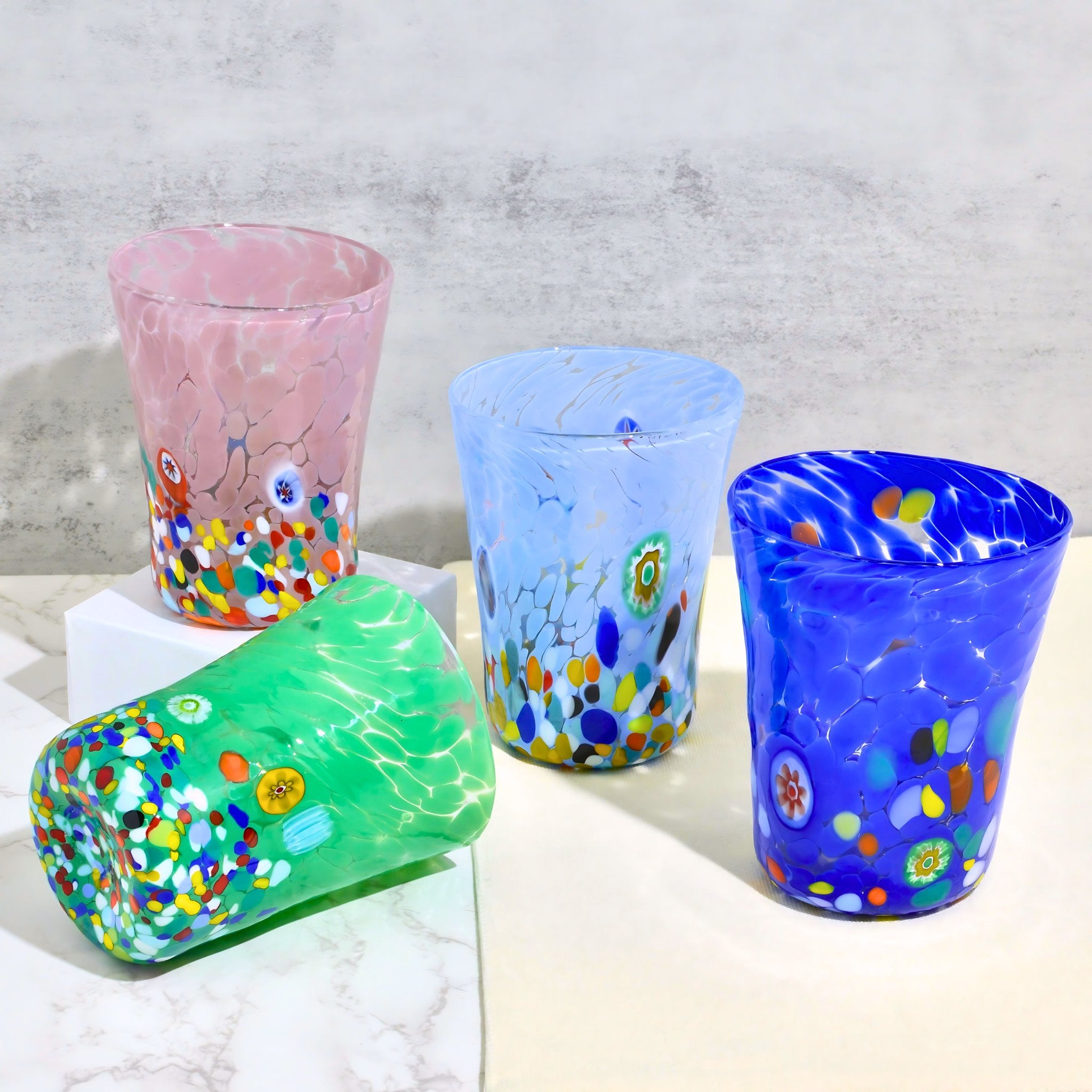 Group of Medici Murano Glass Tumblers by MyItalianDecor featuring vibrant millefiori patterns in lavender, cobalt, light blue, and green.