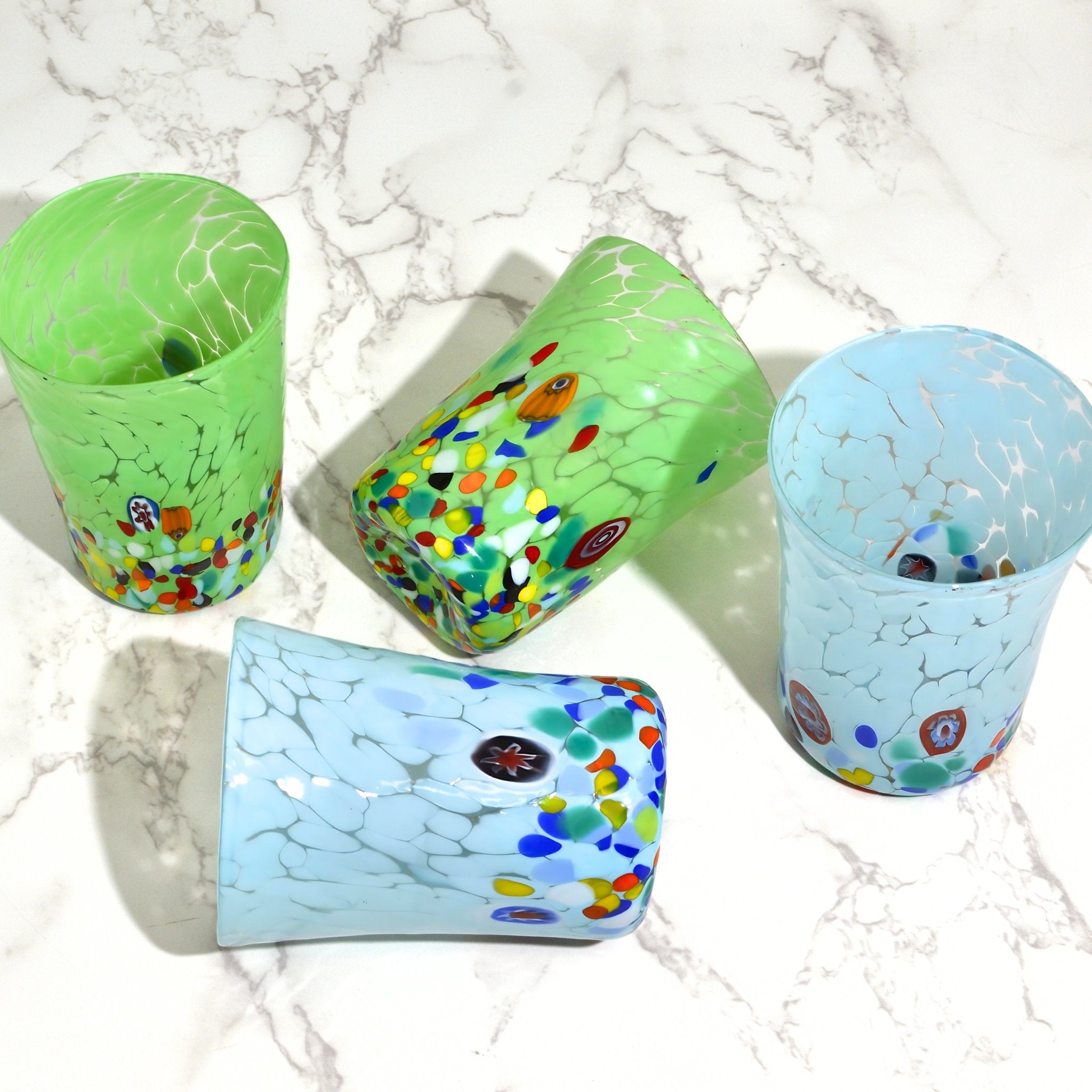 Light green and ice blue Medici Murano glass tumbler with Millefiori pattern, overhead view showcasing intricate glass design.