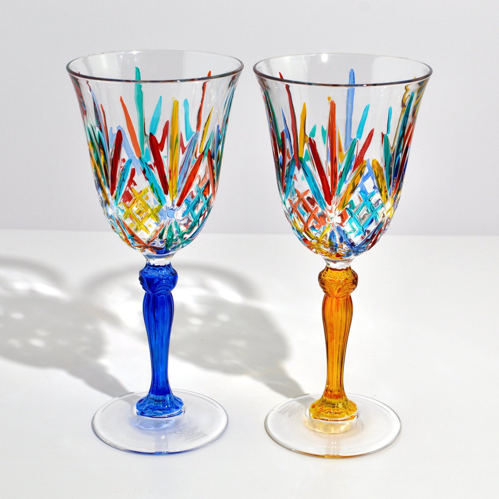 Set of two DZ Melodia wine glasses, hand-painted Italian crystal with red and turquoise accents, elegant for wine tasting.
