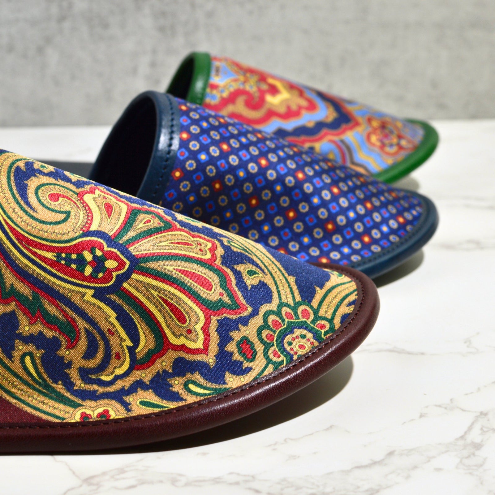 Men's luxury silk and leather slippers from My Italian Decor, displayed in three stylish designs, overhead view.