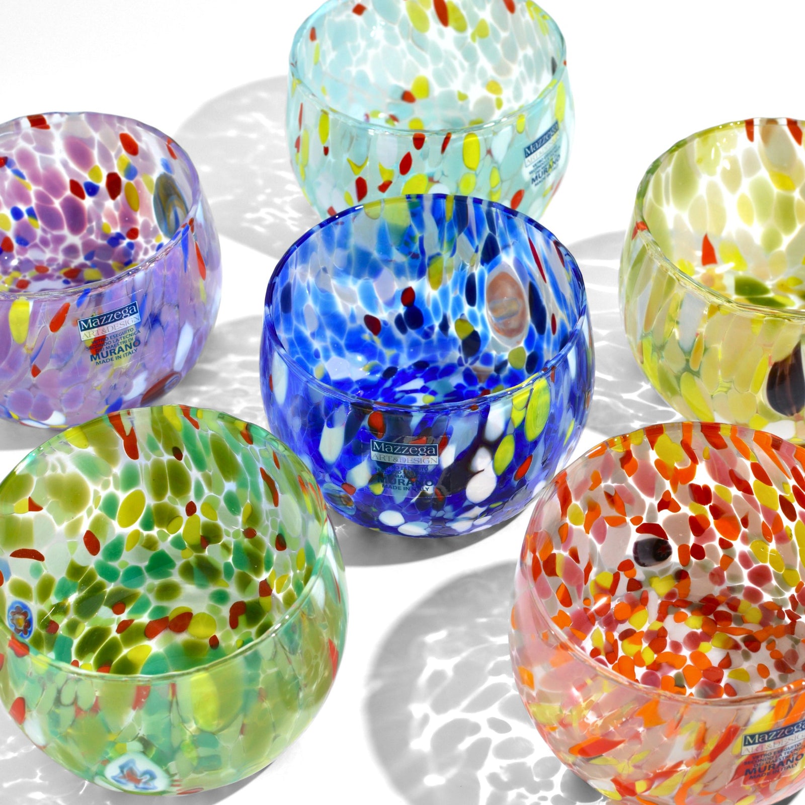 Stacked small Murano glass bowls by MZ, showcasing colorful, handcrafted design in a close-up image.