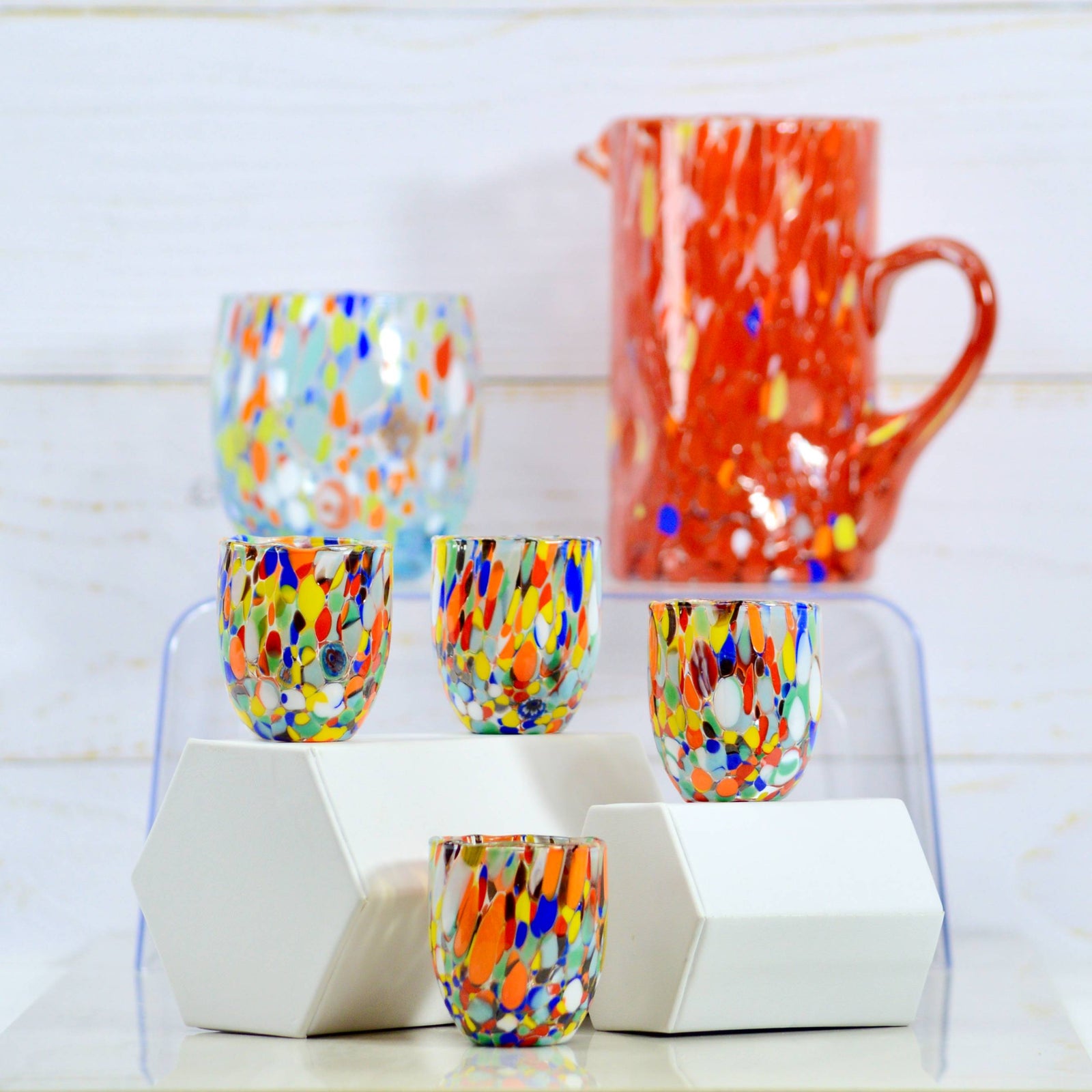 Set of four colorful Murano glass shot glasses with contemporary design, perfect for stylish drinkware displays.