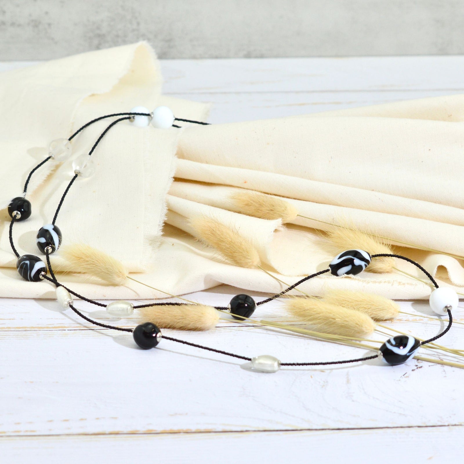 Black Murano glass beaded necklace from Serenissima, handmade in Italy, displayed on a neutral background.