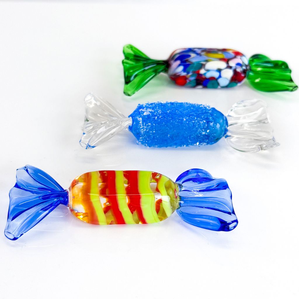Colorful glass candy figurines on a white background