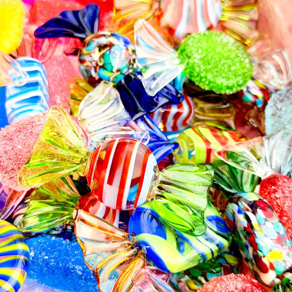 Assorted colorful glass candies on a blue surface
