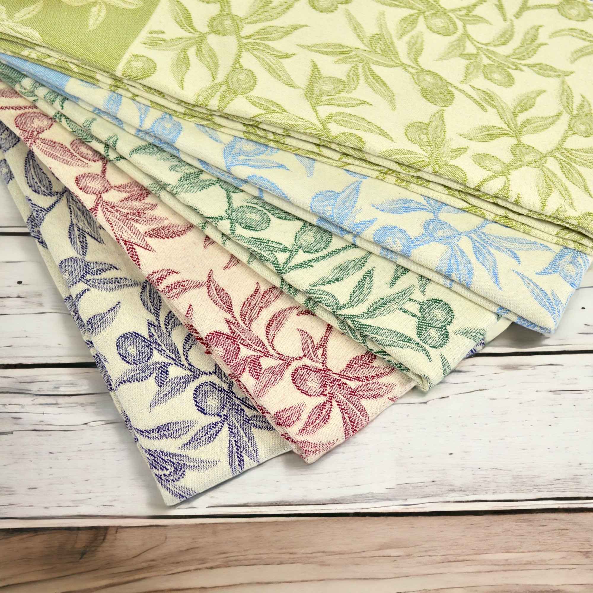 Assorted colors Busatti Oliva kitchen towels, made in Italy, showcasing vibrant woven table linens with intricate patterns.