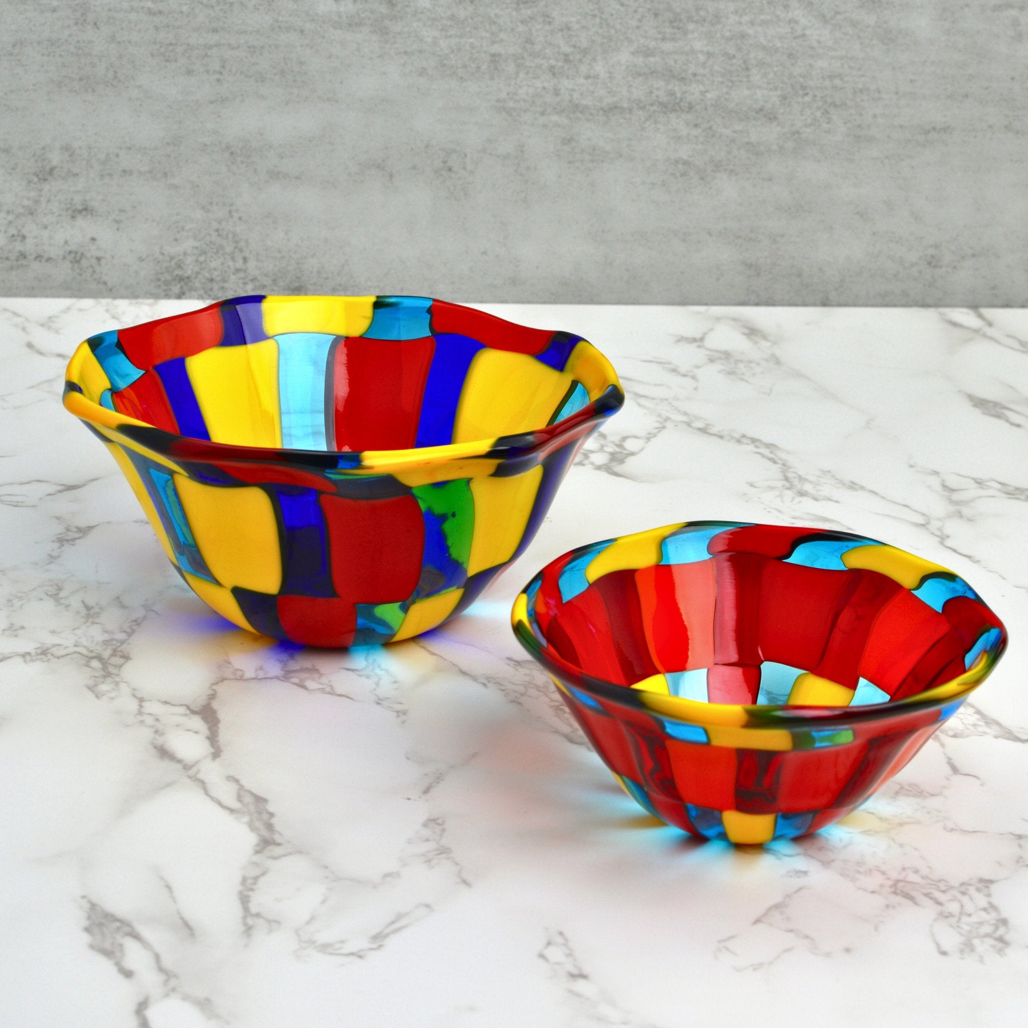 Two Murano glass bowls on a marble table top.