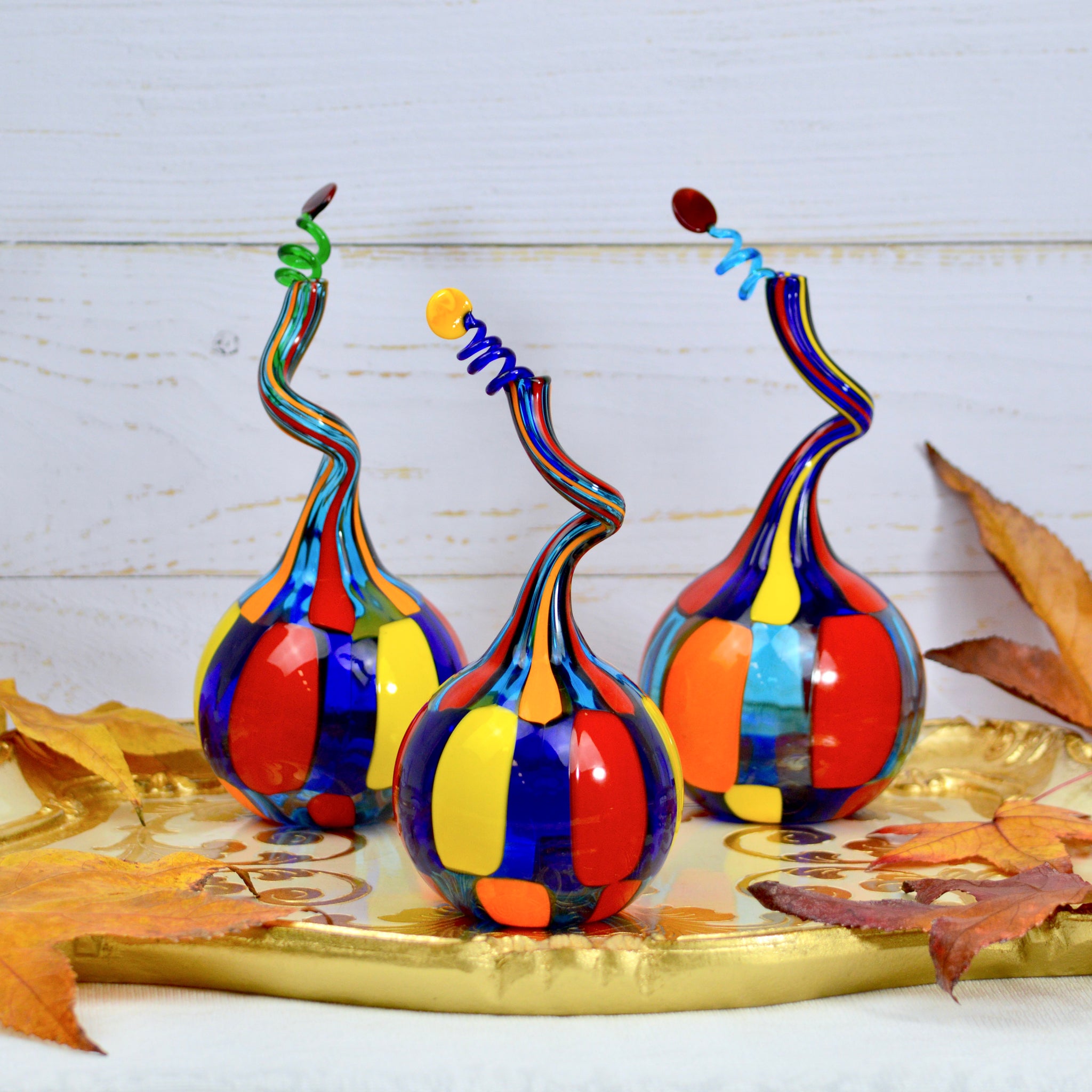 Handblown Pazzia Murano Glass perfume bottle with twisted top, decorative art piece in vibrant, colorful glass.