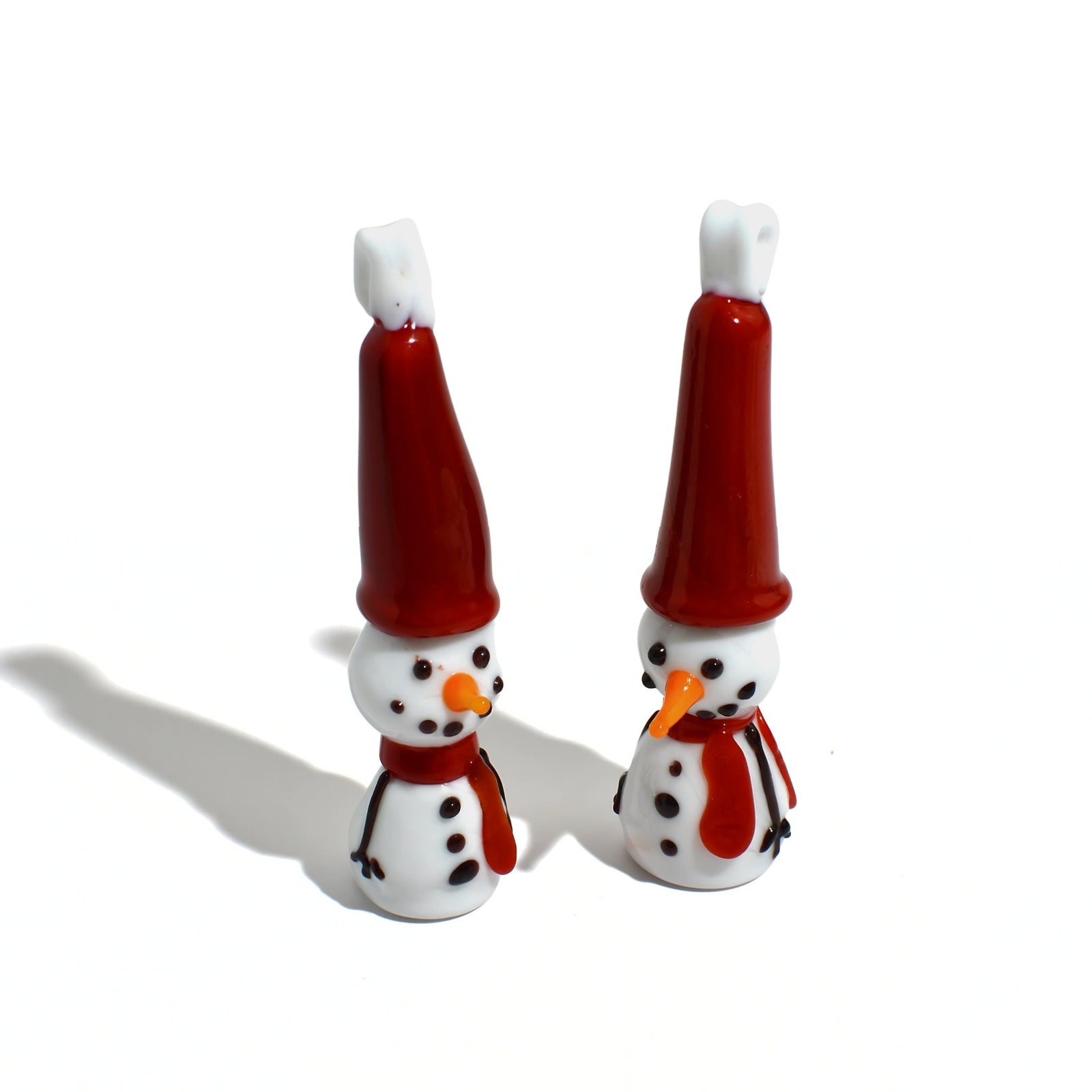 Set of 2 Murano glass snowmen figurines with holiday ornament design, featuring intricate details and a festive winter scene.