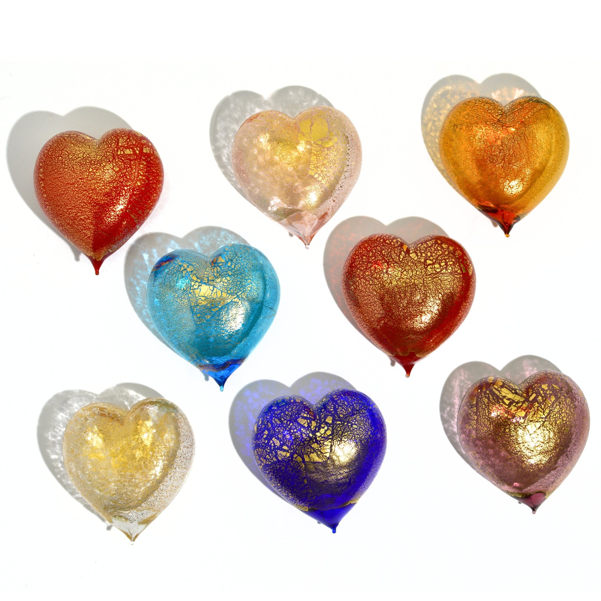 Colorful Murano glass heart figurines with 24K gold accents, made in Italy, arranged in a display.