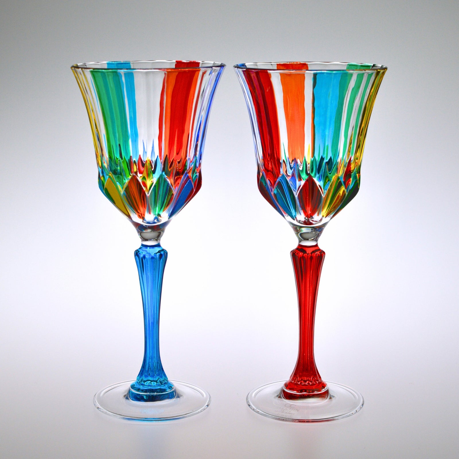 Set of two hand-painted Italian crystal wine glasses with elegant design, showcased under dramatic lighting.