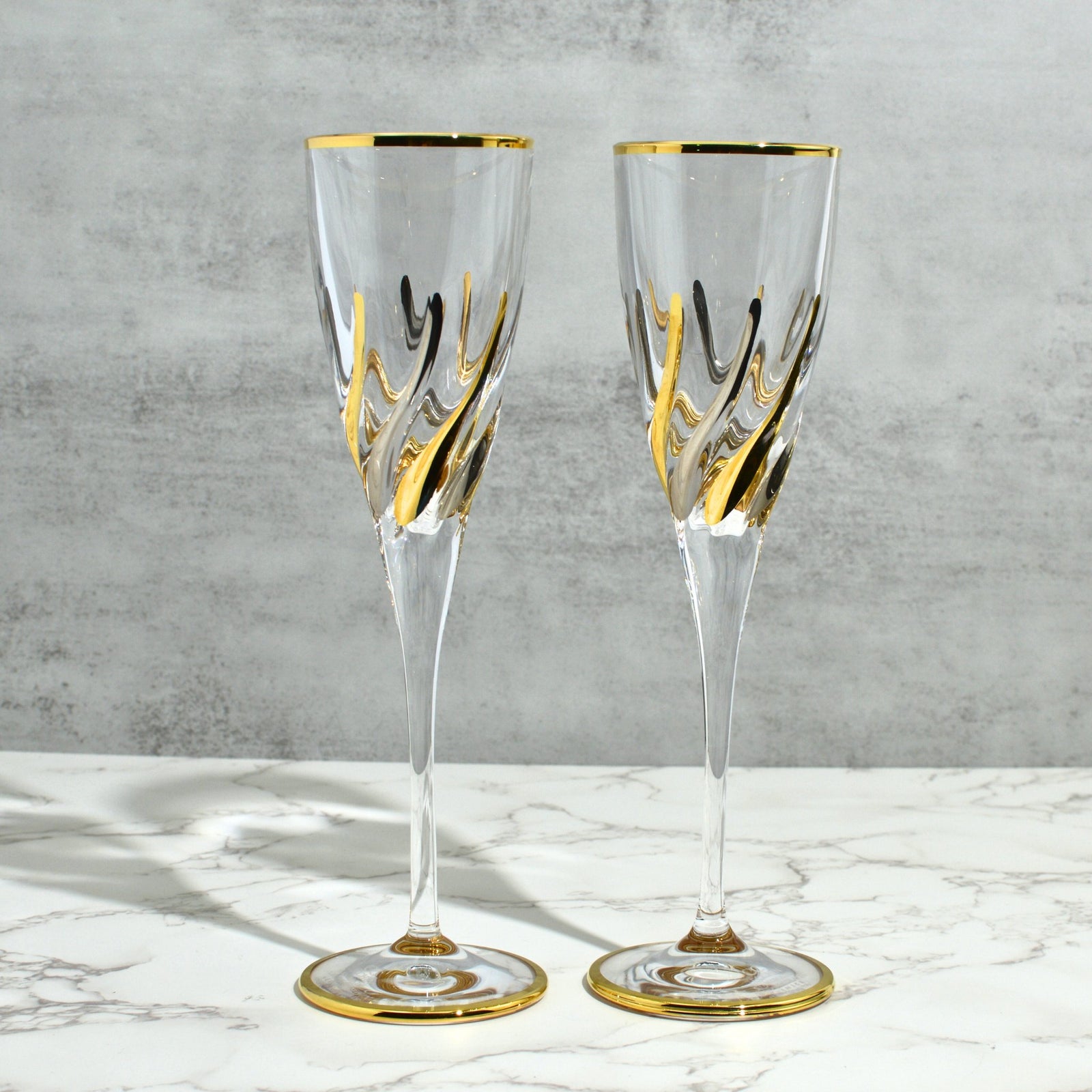 Set of two DZ Trix Italian crystal champagne glasses with platinum and gold accents, elegant stemware for special occasions.
