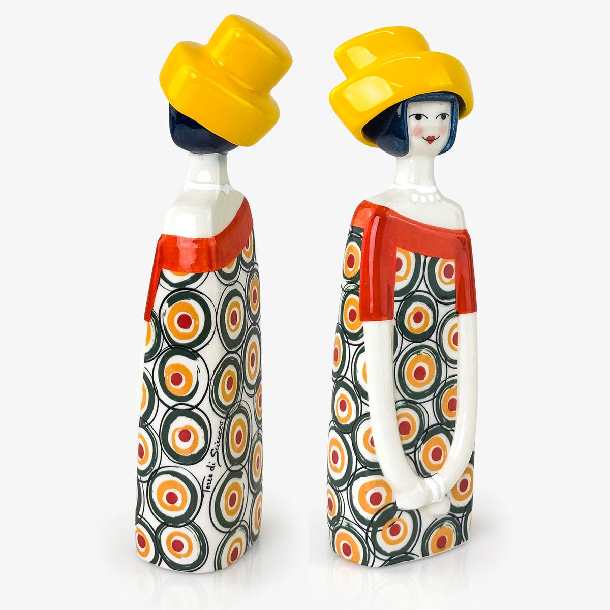 Two decorative ceramic figurines shaped like stylized women in patterned dresses and yellow hats, shown side by side on a light gray background.