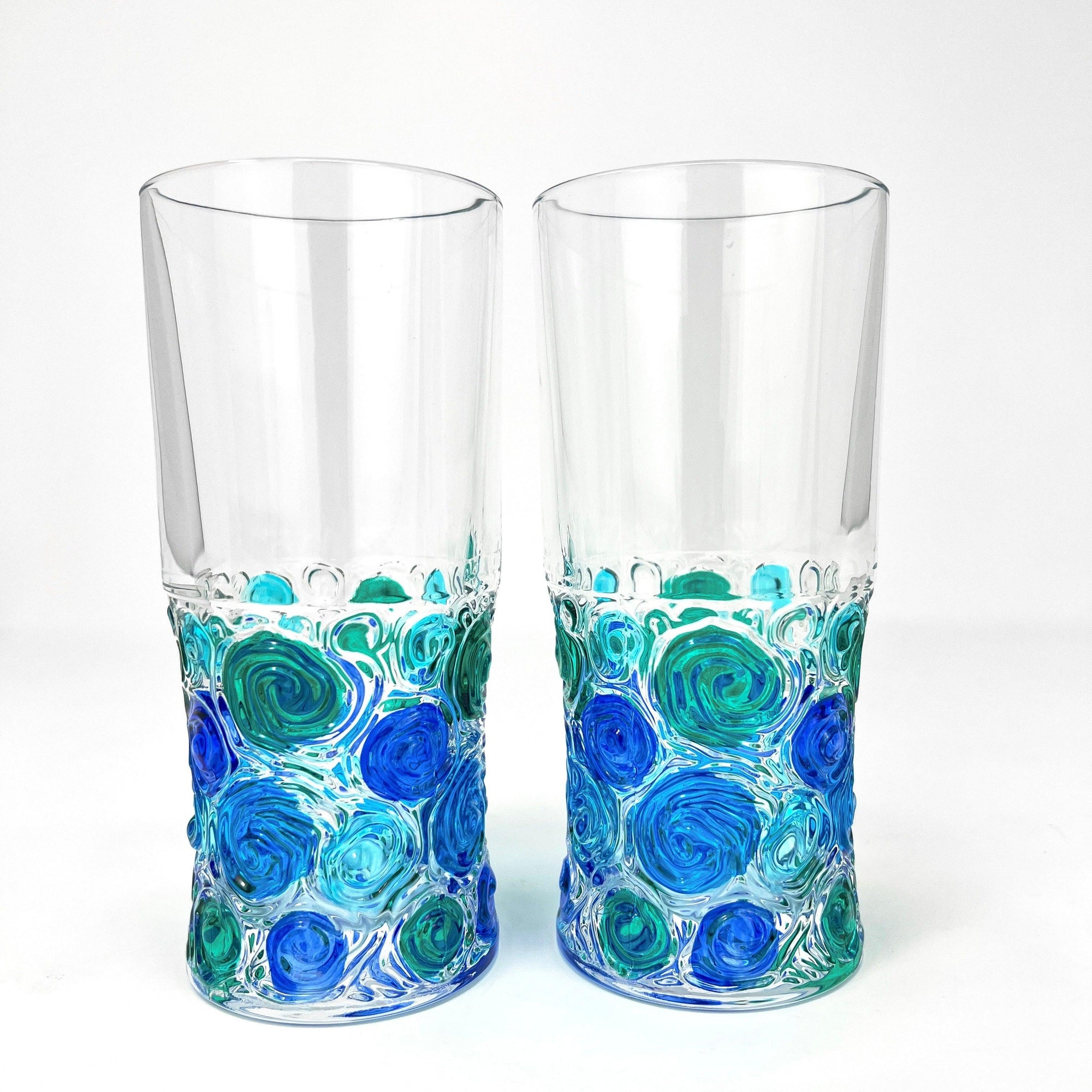 Two Italian Crystal tall drinking glasses with bright blue, green, and turquoise swirls of color on the bottom half.