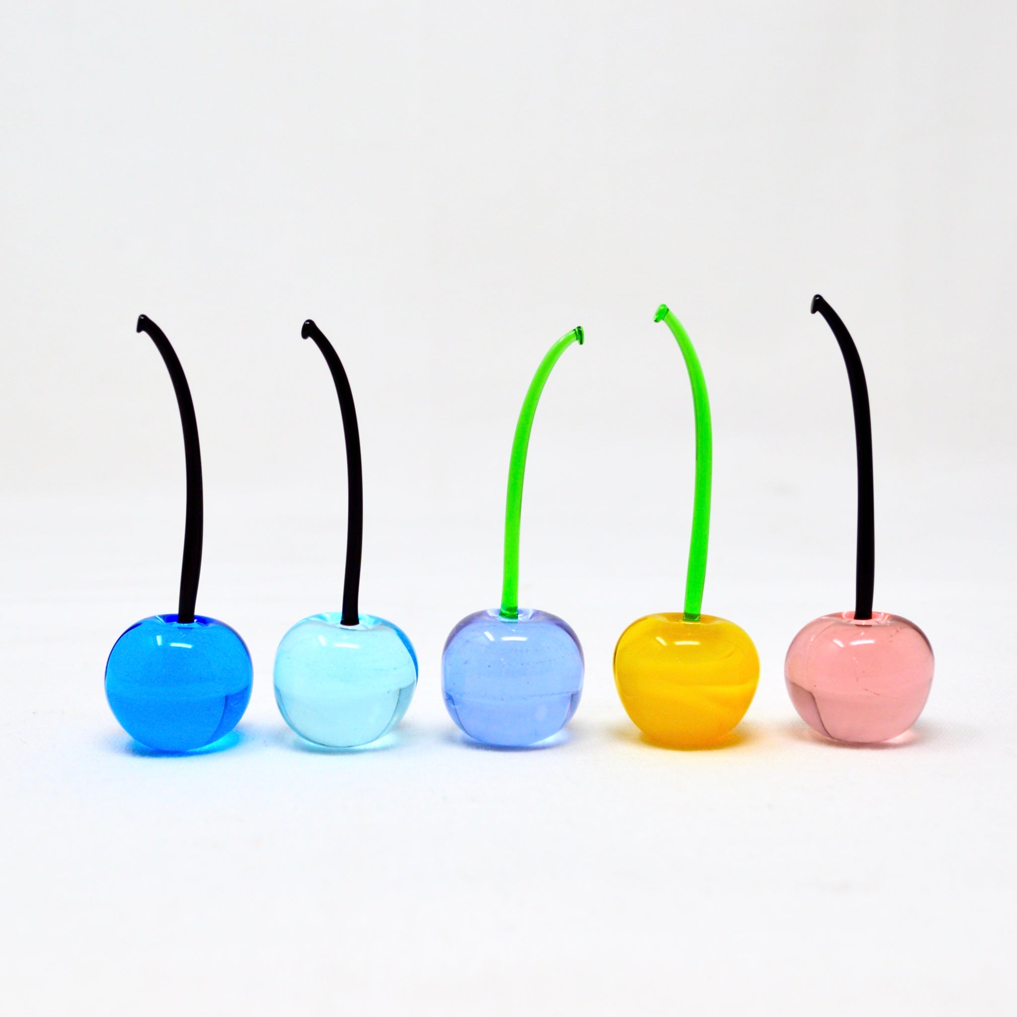 Set of three colorful Murano glass cherries, handmade Italian artificial flora, lifelike and vibrant for decorative displays.