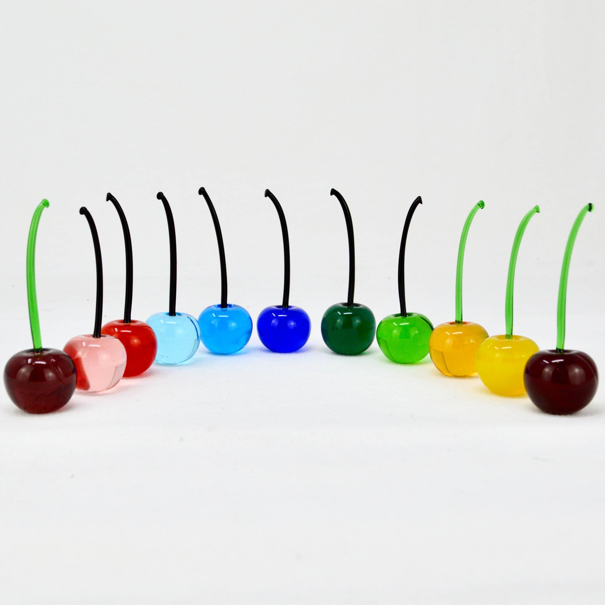 Set of three colorful Murano glass cherries, lifelike artificial flora handcrafted in Italy, vibrant multi-color decorative ornaments.