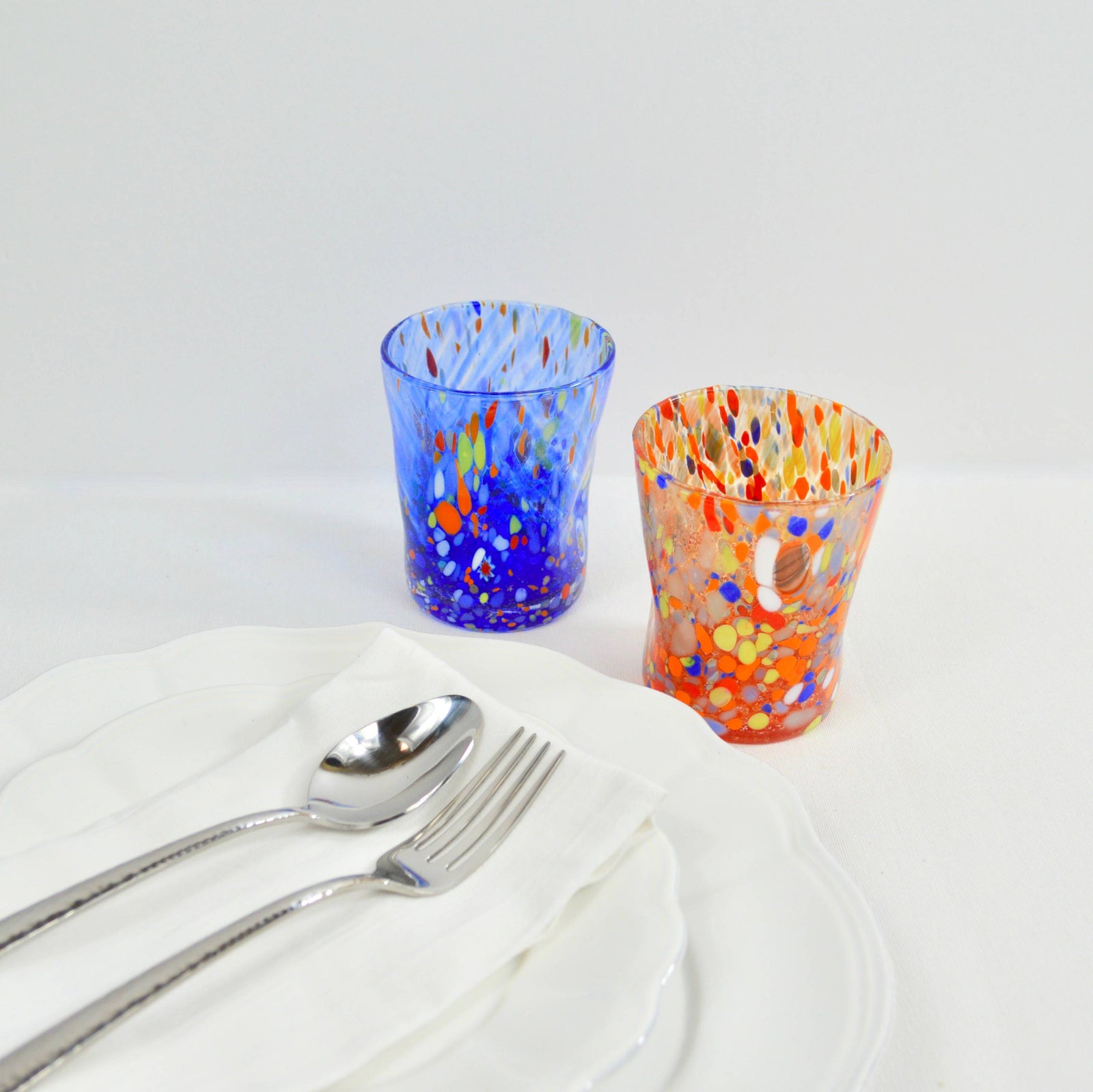 Set of six multicolored Murano glass tumblers, Franco brand, short drinking glasses with vibrant, handcrafted design.
