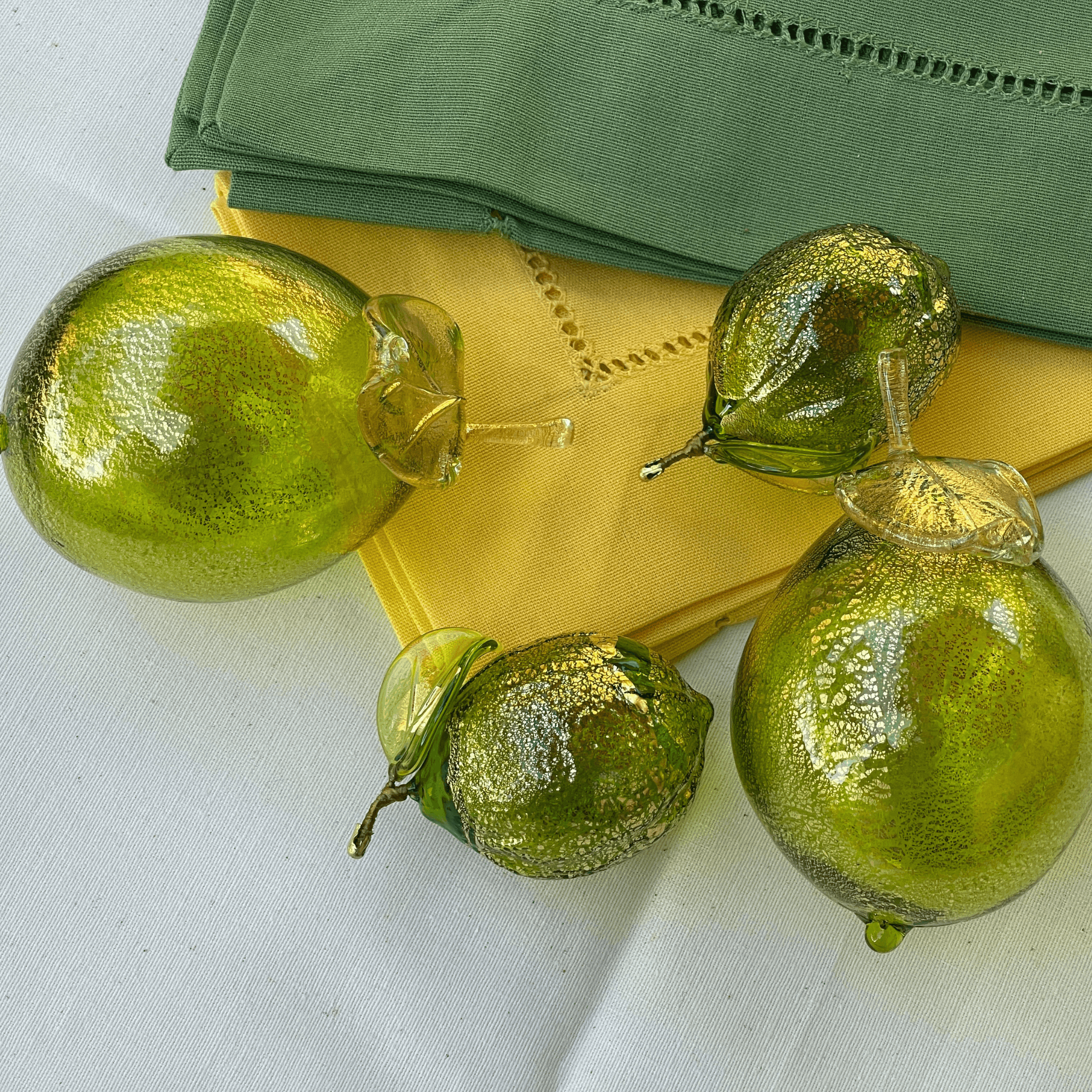 Life-size Murano glass limes in a bowl, handcrafted blown glass artificial fruit from Italy, vibrant and realistic decorative piece.