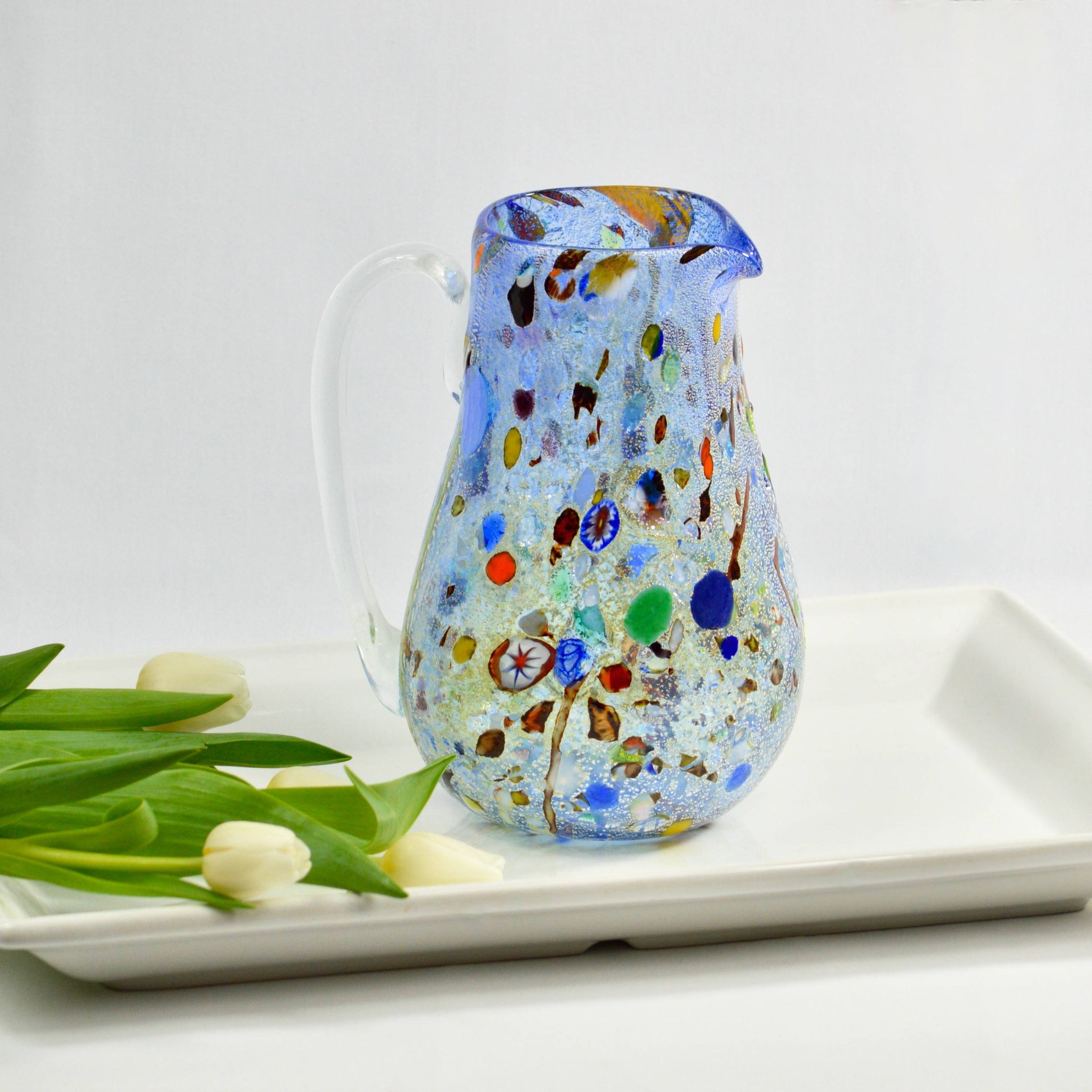 https://myitaliandecor.com/cdn/shop/products/murano-glass-millefiori-alta-pitcher-blue-with-flowers_2048x.jpg?v=1704321129