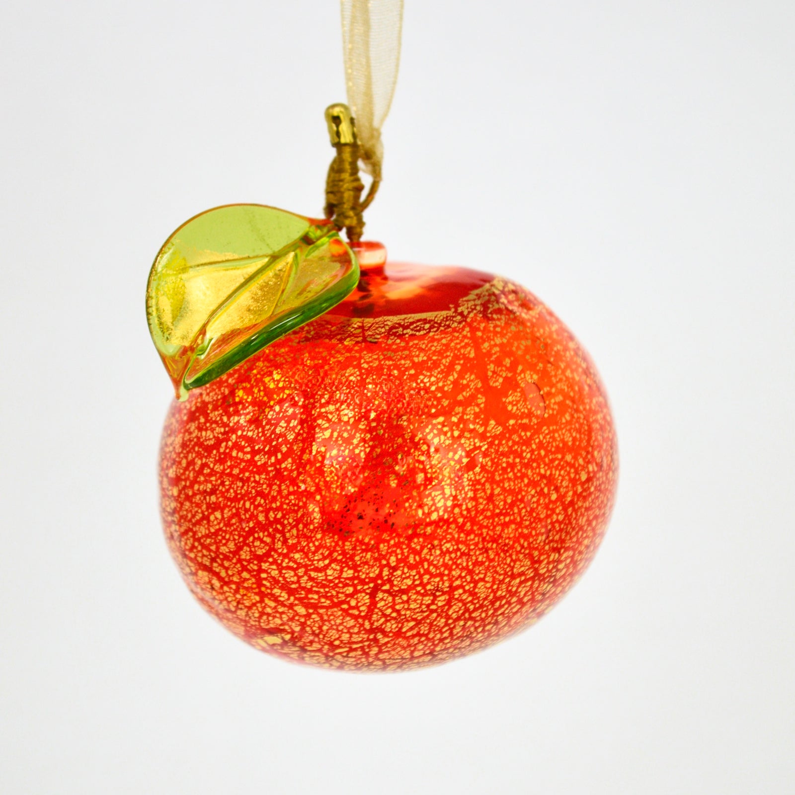 Hand-blown Murano glass orange and white artificial floral ornament by MyItalianDecor on a green background.