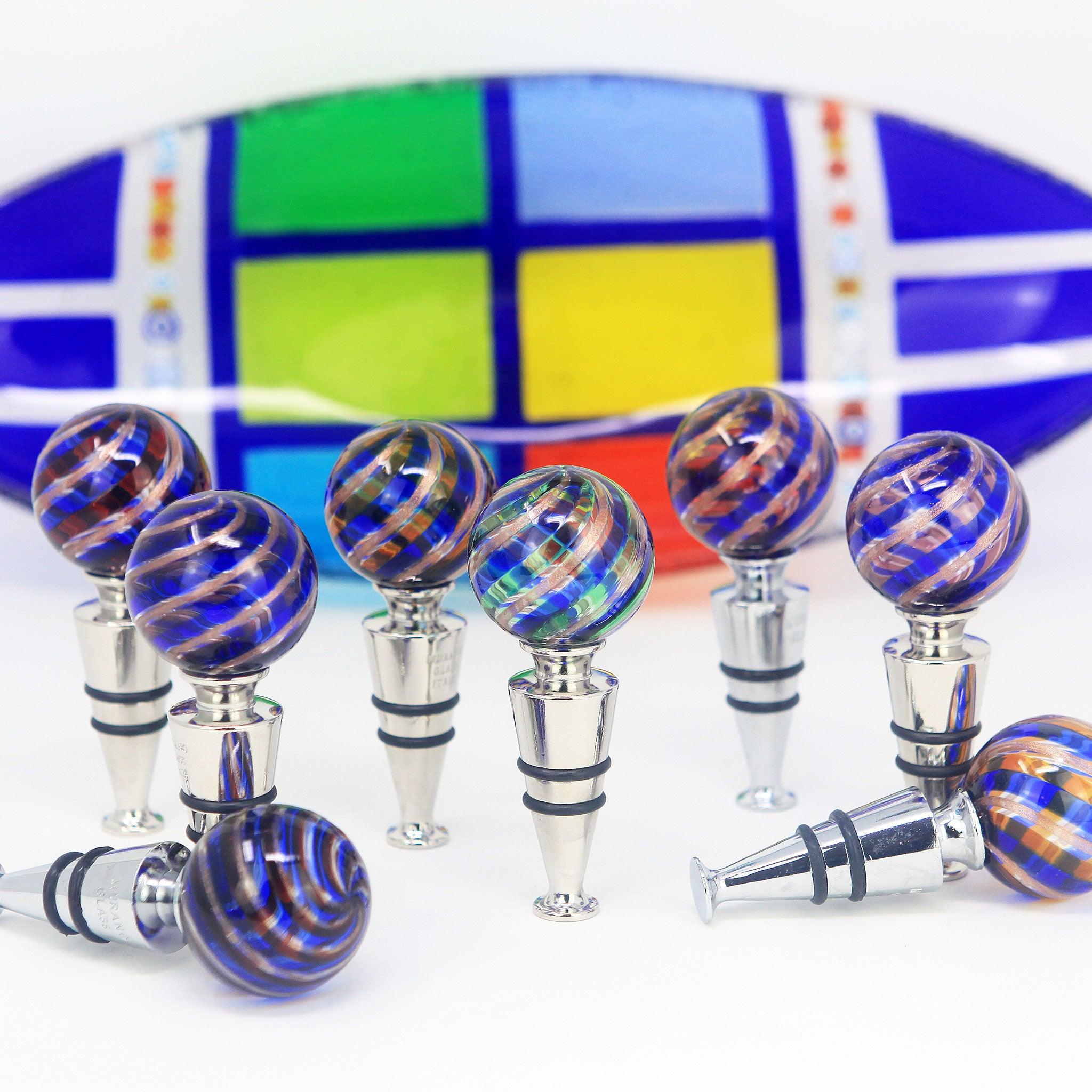 Assorted Murano glass wine stoppers in blue with decorative designs, made in Italy, for sealing wine bottles.